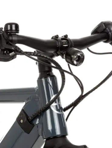 Nahaufnahme des linken und rechten Lenkers eines grauen SD3 URBAN E-Bikes mit Fokus auf den Griff, die Magura Bremse, die Klingel, den Supernova Scheinwerfer, das Bosch Purion Display und die Verkabelung.