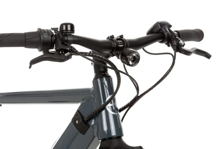 Nahaufnahme des linken und rechten Lenkers eines grauen SD3 URBAN E-Bikes mit Fokus auf den Griff, die Magura Bremse, die Klingel, den Supernova Scheinwerfer, das Bosch Purion Display und die Verkabelung.