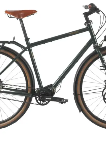 Dunkelgrünes Tout Terrain Tourenrad Silkroad mit braunem Ledersattel, Gepäckträgern vorne und hinten sowie einem Pinion-Mittendrive-Getriebe.