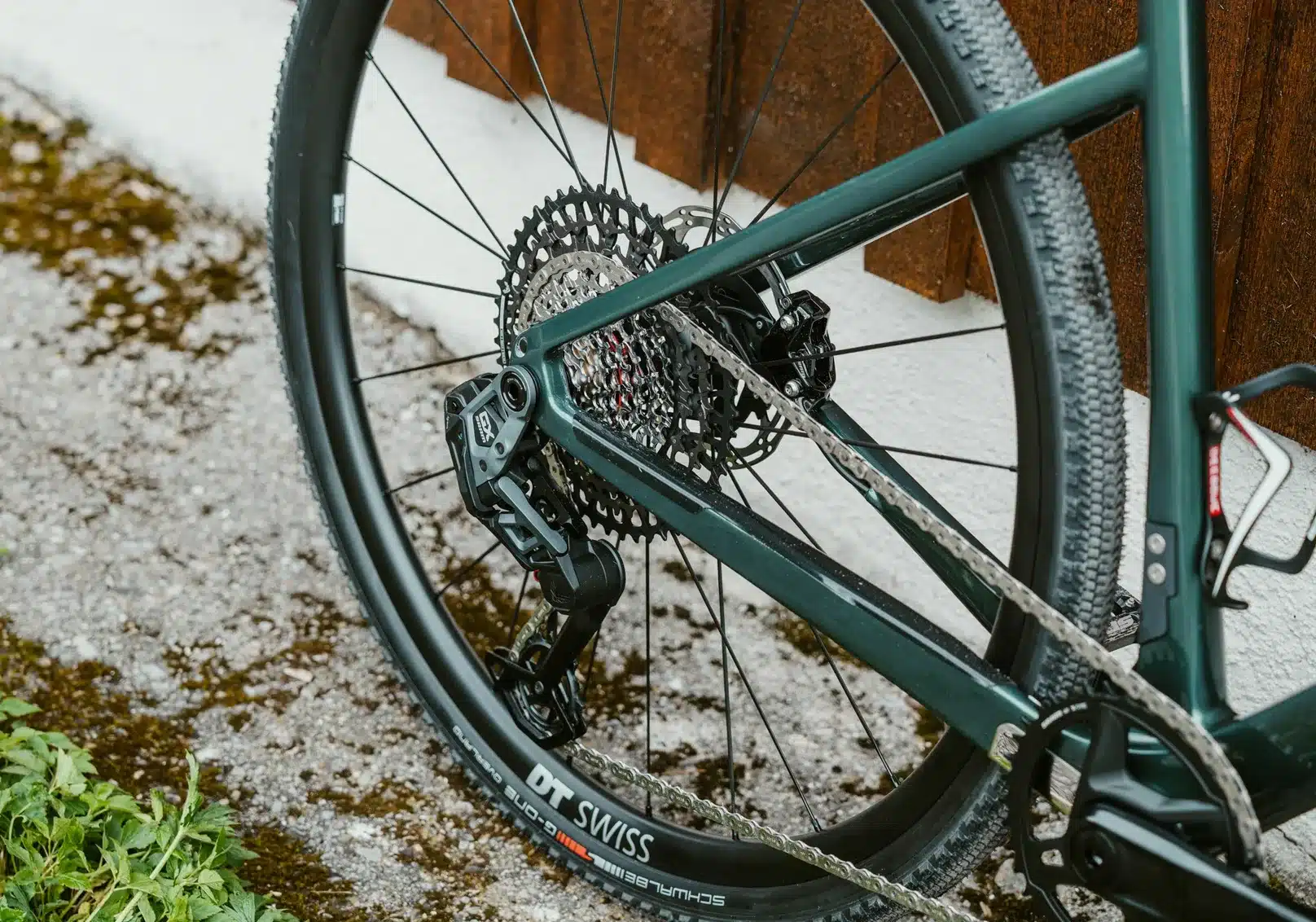 Nahaufnahme der Kette, Kassette und des Schaltwerks eines SIMPLON GRID :eLight Fahrrads, das auf einem steinigen Untergrund steht.