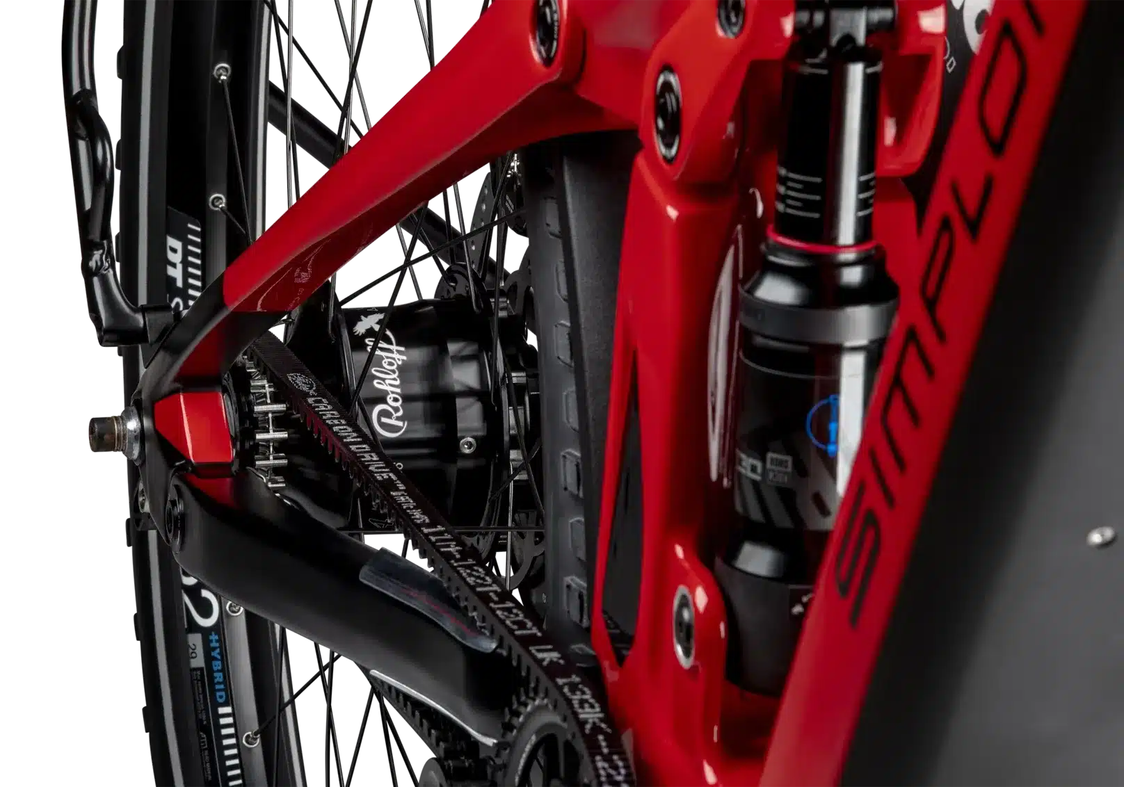 Detailaufnahme des Hinterbaus eines roten SIMPLON Stomp SUV :e E-Mountainbikes mit Fokus auf den RockShox Dämpfer und den Gates Carbon Drive Riemenantrieb.