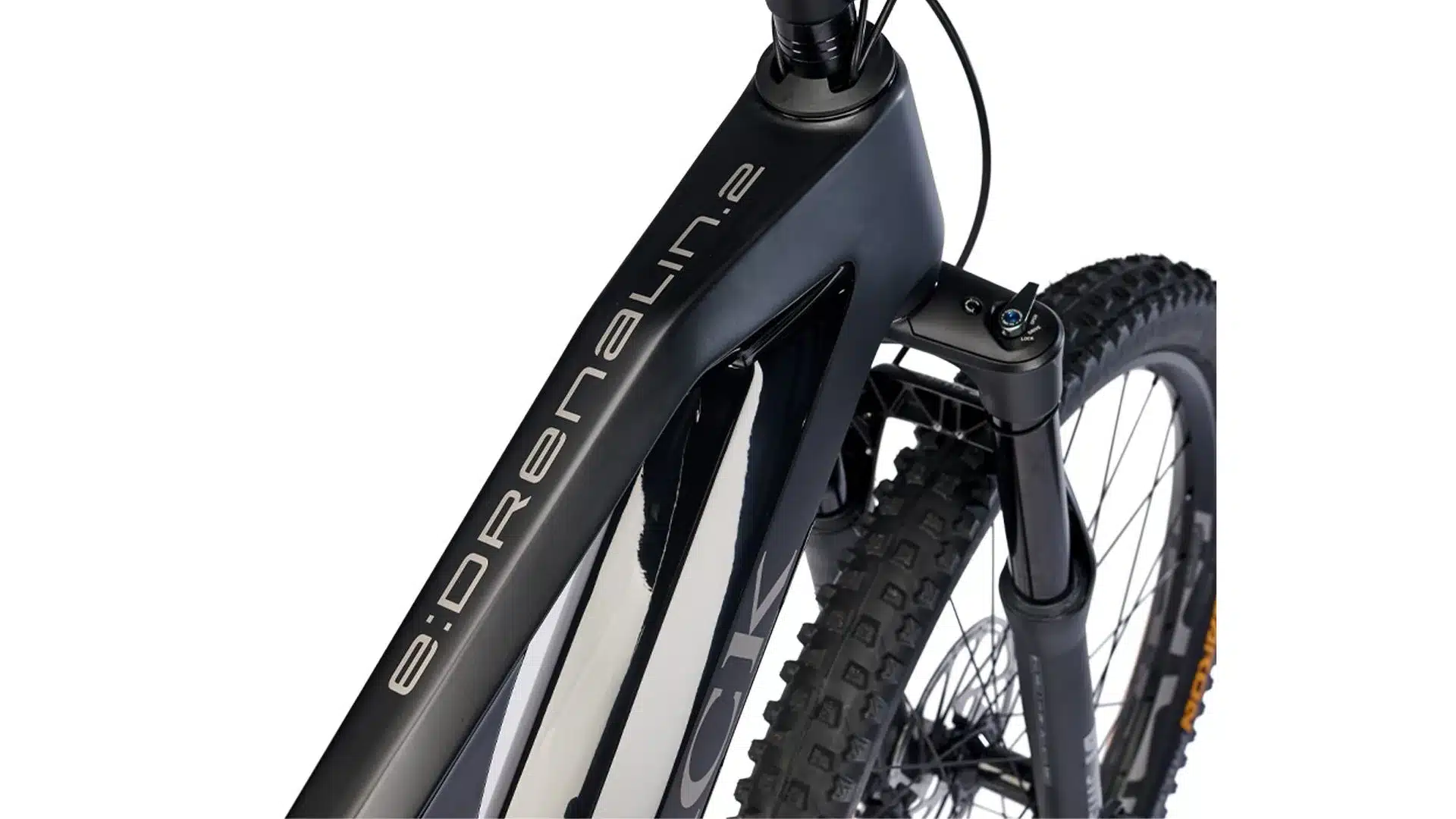 Detailansicht des schwarzen Carbonrahmens eines Storck e:drenalin.2 E-Mountainbikes mit silberner Schrift und der schwarzen Federgabel sowie dem Vorderrad eines Mountainbikes.