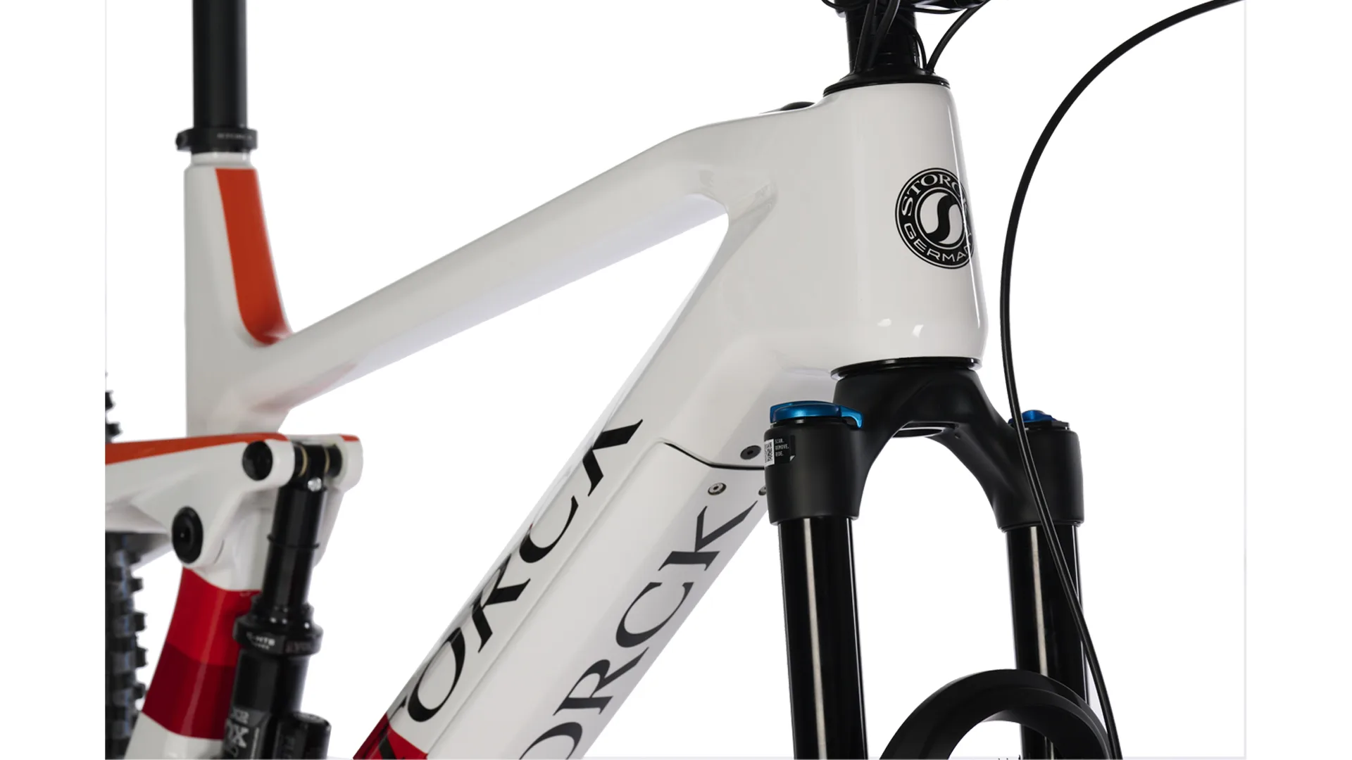 Detailansicht des vorderen Rahmens eines Storck e:drenic.2 Enduro E-Mountainbikes in Weiß mit roten Akzenten, inklusive Lenkerrohr und Federgabel.