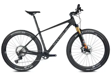 Seitenansicht eines schwarzen Storck Rebel.4 Cross-Country-Mountainbikes mit 29-Zoll-Laufrädern und goldfarbener Federgabel.