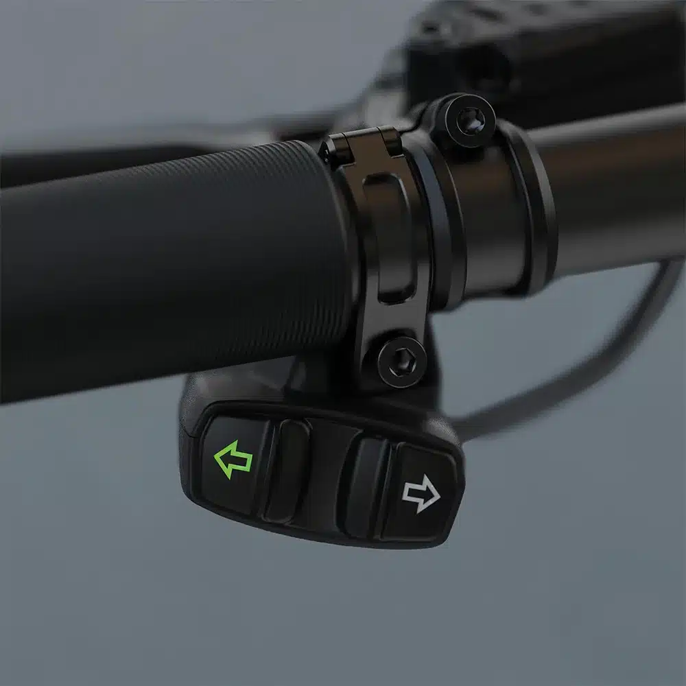 Nahaufnahme der TURNTEC T4 Blinker-Bedieneinheit am Fahrradlenker mit beleuchteten Richtungspfeilen
