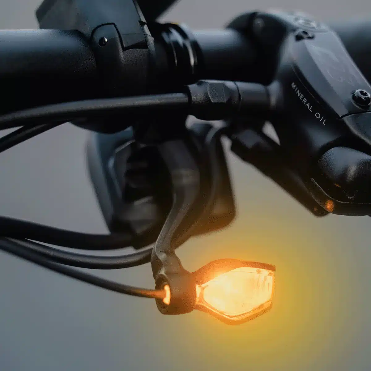 Nahaufnahme eines aktivierten TURNTEC T4 Blinkers am Fahrradlenker