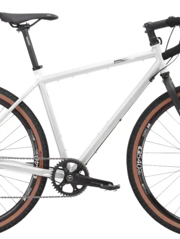 Graues Stahl-Gravelbike mit Dropbar-Lenker, breiten Reifen und Scheibenbremsen, das für Bikepacking und Abenteuer konzipiert ist.