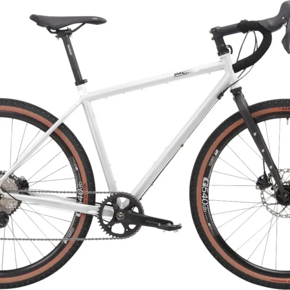 Graues Stahl-Gravelbike mit Dropbar-Lenker, breiten Reifen und Scheibenbremsen, das für Bikepacking und Abenteuer konzipiert ist.