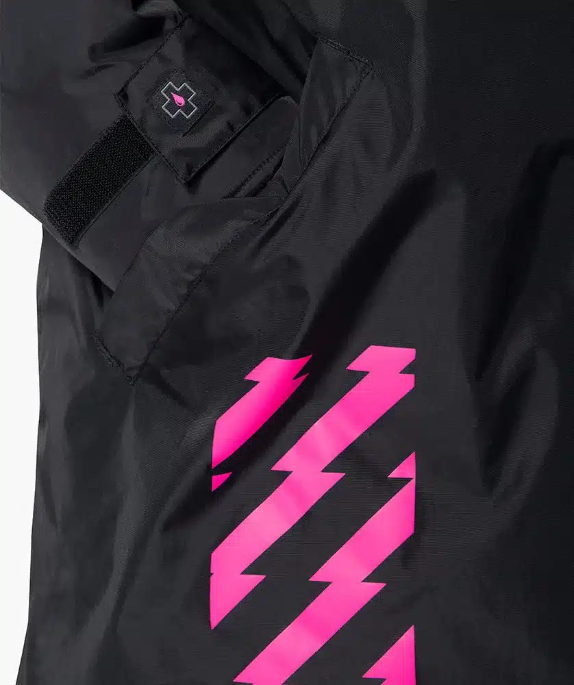 Nahaufnahme einer schwarzen All Weather Robe mit einem neonpinken Blitz-Design auf der rechten Seite und einem kleinen Logo-Patch auf der linken Brusttasche.