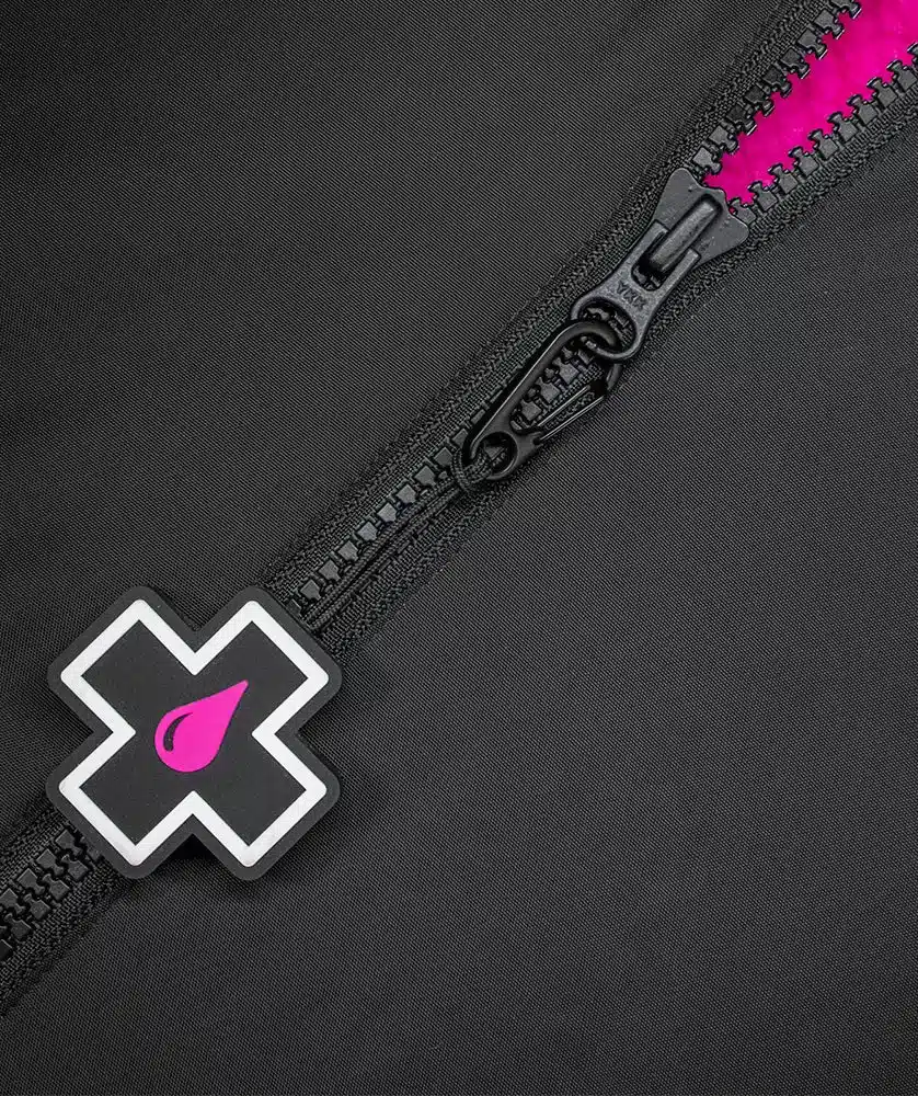 Nahaufnahme eines schwarzen Reißverschlusses mit einem pinken Band und einem weißen Kreuz-Logo mit einem pinken Wassertropfen einer All Weather Robe.