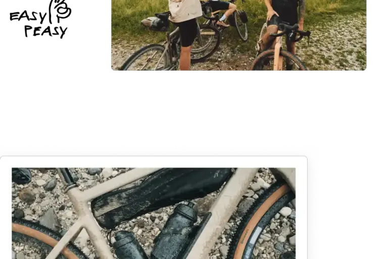 Ein sandfarbenes ROSE Backroad AL Gravelbike mit zwei schwarzen Trinkflaschen, die am Rahmen befestigt sind, liegt auf Schotter. Ein schwarzer Rahmentasche ist ebenfalls angebracht. Die Reifen sind breit und haben einen braunen Rand.