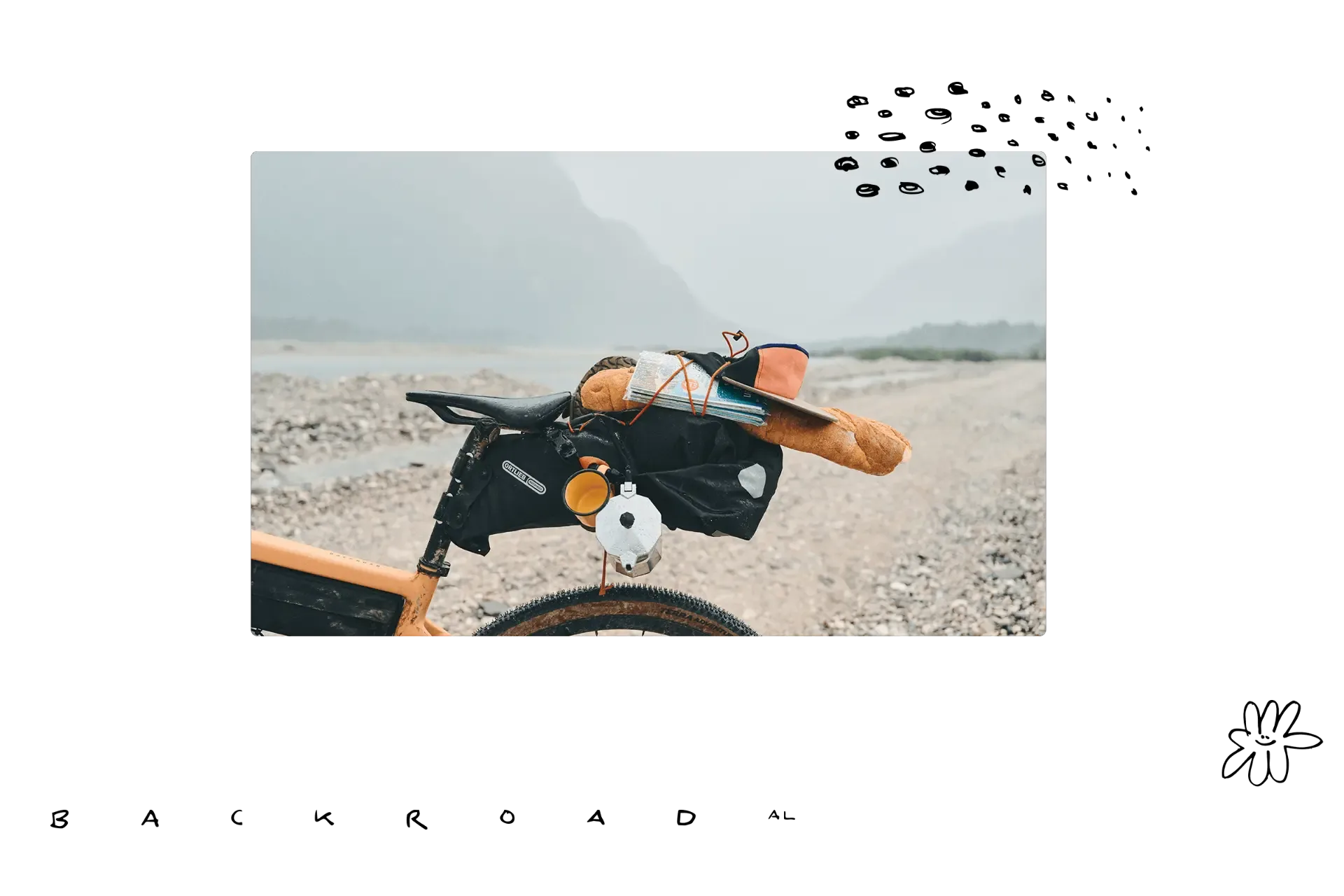 Detailaufnahme eines gelben ROSE Backroad AL Gravelbikes, beladen mit Satteltaschen, einer Kaffeekanne, einer Tasse und einem Baguette, bereit für eine Reise auf einem Schotterweg im Gebirge.