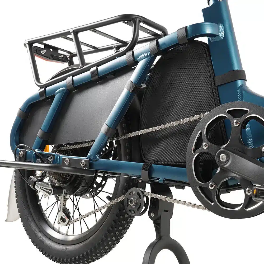 Detailaufnahme des blauen CMACEWHEEL HQ20 Cargo E-Bikes, Fokus auf den Antriebsstrang mit Hinterrad, Shimano-Schaltwerk, Kette und schwarzem Gepäckträger.