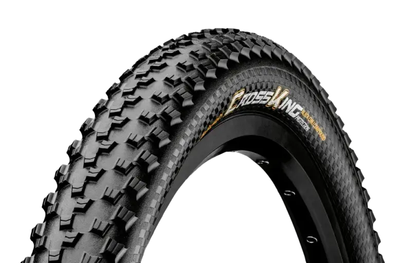 Detailaufnahme des schwarzen Continental Cross King ProTection MTB-Reifens mit markantem Profil und dem Schriftzug 'CROSS KING PROTECTION' auf schwarzem Hintergrund.