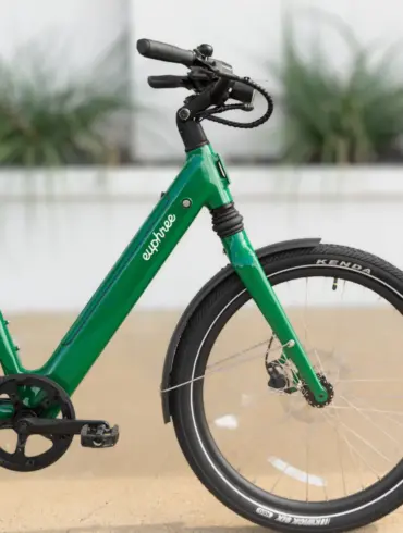 Ein grünes E-Bike, das Solar Sparrow, von der Seite fotografiert. Man sieht den tiefen Einstieg, den Rahmen mit dem Schriftzug 'euphree', die Federgabel, das Vorderrad mit Kenda-Reifen und Schutzblech.