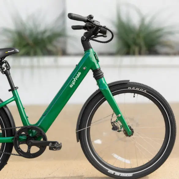 Ein grünes E-Bike, das Solar Sparrow, von der Seite fotografiert. Man sieht den tiefen Einstieg, den Rahmen mit dem Schriftzug 'euphree', die Federgabel, das Vorderrad mit Kenda-Reifen und Schutzblech.