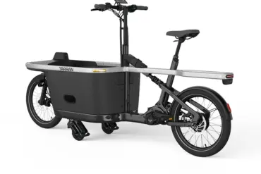 Seitenansicht eines schwarzen TARRAN T1 Pro E-Cargobikes mit einer integrierten Transportbox vorne und einem Gepäckträger hinten.