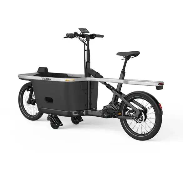Seitenansicht eines schwarzen TARRAN T1 Pro E-Cargobikes mit einer integrierten Transportbox vorne und einem Gepäckträger hinten.