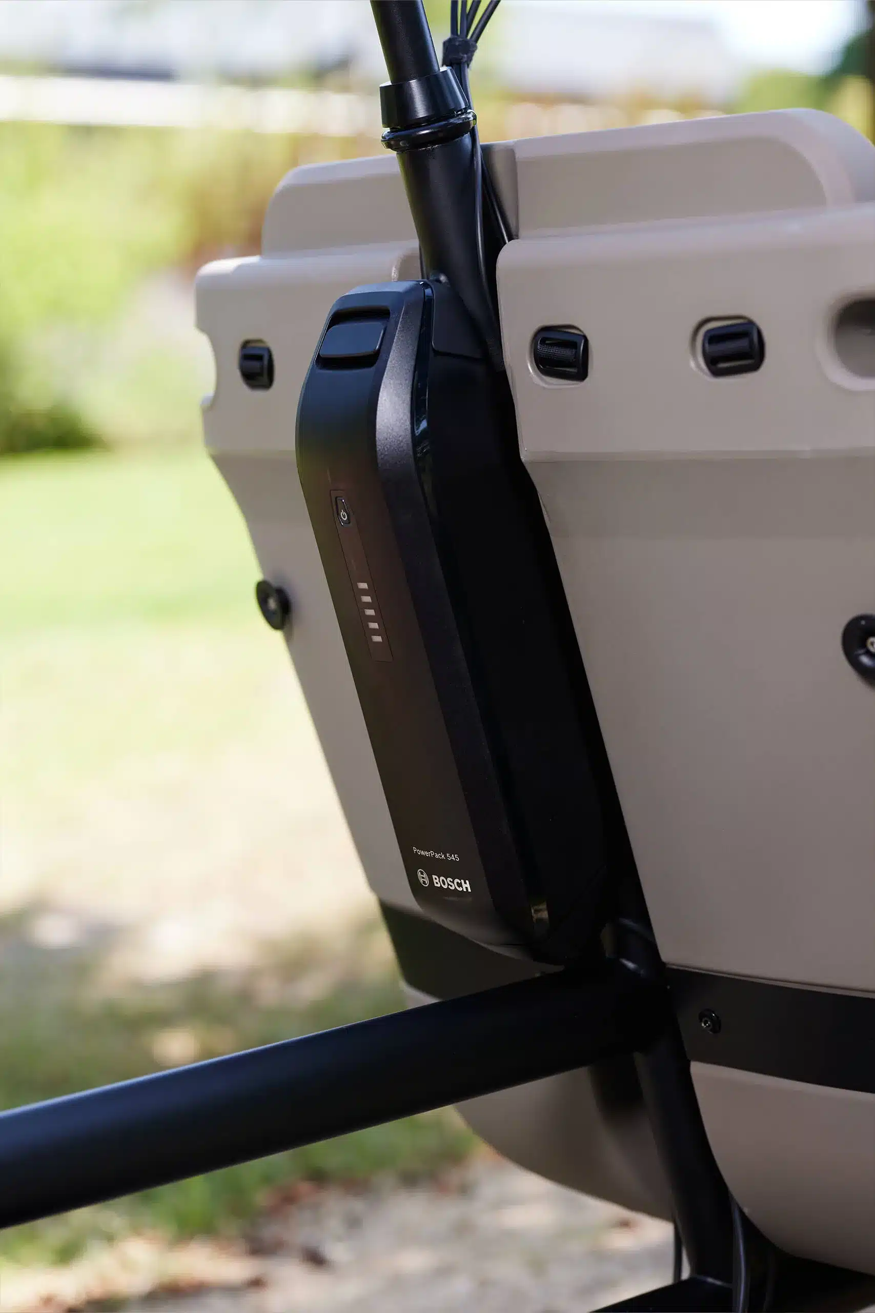 Bosch PowerPack 545 Akku, montiert an der Seite der Ladebox eines Dolly Joy Lastenrads. Die Anzeige für den Ladezustand ist sichtbar.