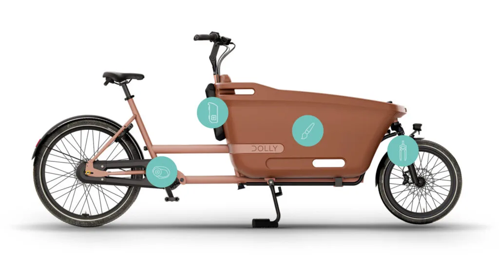Seitenansicht eines braunen Dolly Joy Lastenrads mit großer Transportbox vorne. Das Fahrrad ist für Familien und Pendler konzipiert und bietet Platz für Einkäufe oder Kinder.