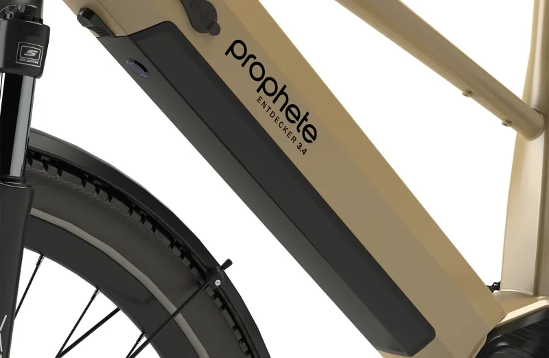 Nahaufnahme des Rahmens eines beigefarbenen Prophete Entdecker 3.4 E-Trekkingrads mit sichtbarem Akku und dem Markenschriftzug.