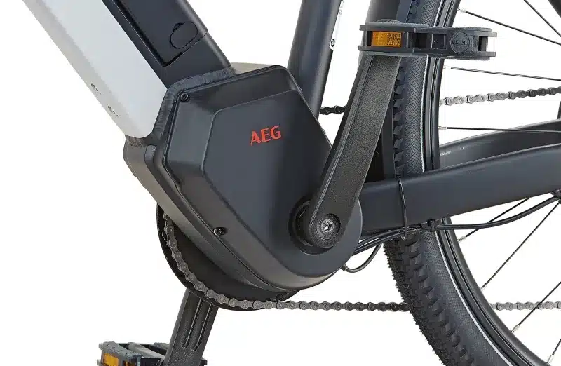 Nahaufnahme des schwarzen AEG-Mittelmotors eines E-Trekkingrads, inklusive Kurbel und Kette.