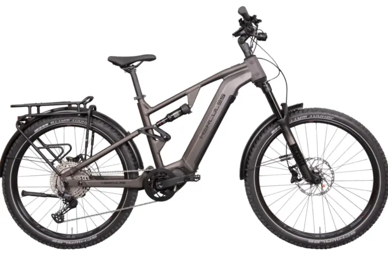 Hercules Nos FS SUV 2.2 E-Bike, ein vollgefedertes graues E-SUV-Fahrrad mit Gepäckträger, Federung vorne und hinten sowie breiten Reifen.