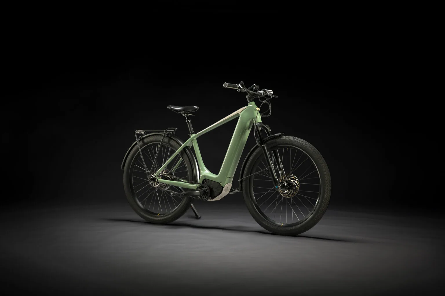 Ein hellgrünes Heritage Style E-Bike steht auf einem dunklen Hintergrund, von der Seite fotografiert.