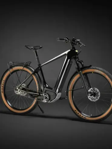 Ein schwarzes Heritage Style Escapade Elektrofahrrad steht freistehend vor einem dunklen Hintergrund.