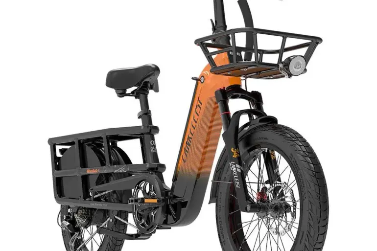 Ein oranges und schwarzes Lankeleisi Wombat-1 Elektrofahrrad mit breiten Reifen, Frontkorb, Gepäckträger und Vorderfedergabel, ausgestellt in einer Studioaufnahme.