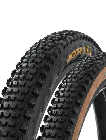 Nahaufnahme von zwei Continental Magnotal Mountainbike-Reifen, ein Reifen mit brauner Seitenwand ist im Vordergrund, dahinter ein Reifen mit schwarzer Seitenwand.