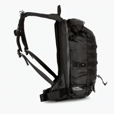 Seitenansicht eines schwarzen Muc-Off Ride Pack Rucksacks mit Molle-System und Rolltop-Verschluss.