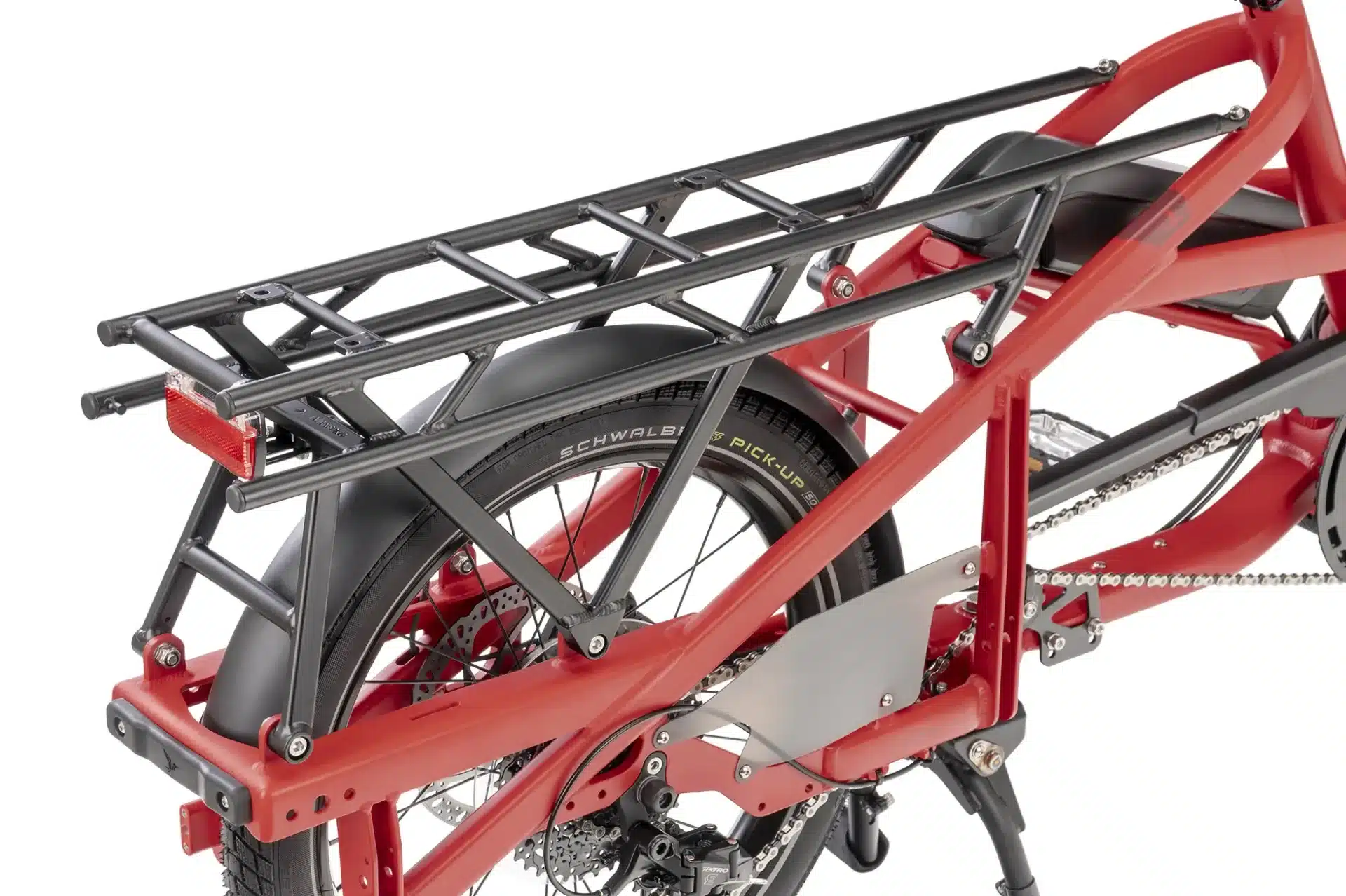 Detailaufnahme des roten Tern Quick Haul Long D9 Cargobikes, das den verstärkten Gepäckträger, das Schutzblech, das Hinterrad mit Scheibenbremse und die Kettenschaltung zeigt.