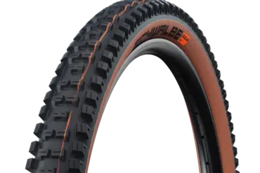 Nahaufnahme eines Schwalbe Big Betty Fahrradreifens mit brauner Seitenwand und schwarzem Profil auf einem Felgenrand.