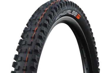 Nahaufnahme des Schwalbe Magic Mary Reifens mit orangefarbenen Akzenten und grobstolligem Profil, geeignet für Downhill und Enduro.