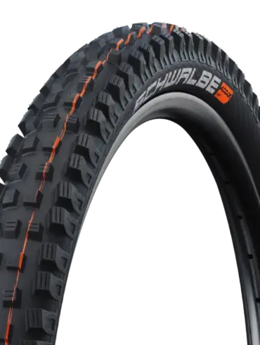 Nahaufnahme des Schwalbe Magic Mary Reifens mit orangefarbenen Akzenten und grobstolligem Profil, geeignet für Downhill und Enduro.