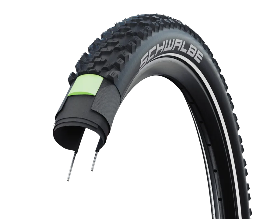Detailansicht des Fahrradreifens Schwalbe Smart Sam Plus, der eine verstärkte Seitenwand mit grüner Einlage zur Pannensicherheit zeigt.