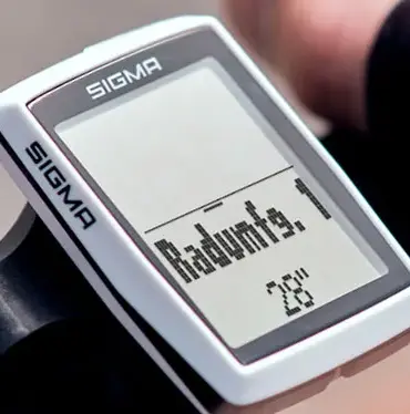 Nahaufnahme eines SIGMA BC 12.0 WR Fahrradcomputers, montiert am Lenker eines Fahrrads. Das Display zeigt Informationen zur Reifengröße.