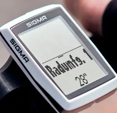 Nahaufnahme eines SIGMA BC 12.0 WR Fahrradcomputers, montiert am Lenker eines Fahrrads. Das Display zeigt Informationen zur Reifengröße.