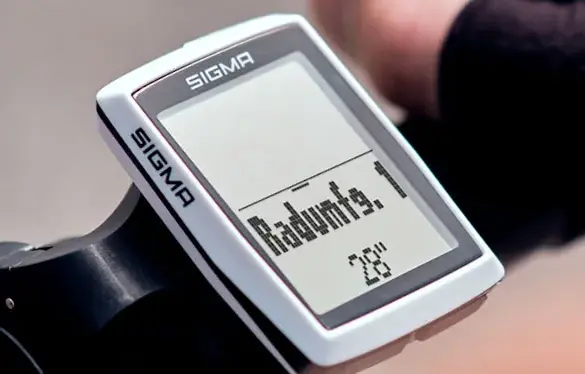 Nahaufnahme eines SIGMA BC 12.0 WR Fahrradcomputers, montiert am Lenker eines Fahrrads. Das Display zeigt Informationen zur Reifengröße.