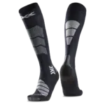 Nahaufnahme eines Paares kniehoher, dunkler Socken mit strategisch platzierten grauen und weißen Verstärkungen und einem Markensymbol.