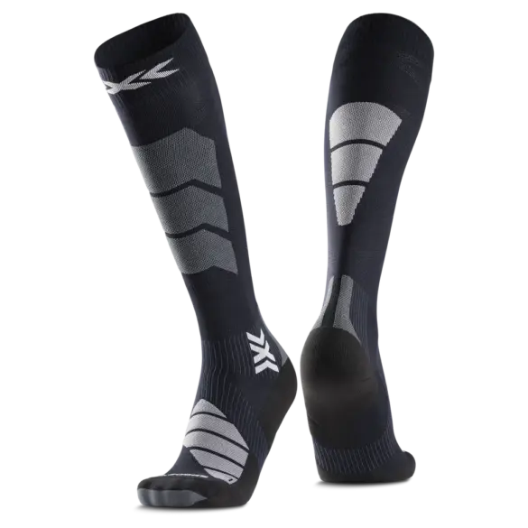 Nahaufnahme eines Paares kniehoher, dunkler Socken mit strategisch platzierten grauen und weißen Verstärkungen und einem Markensymbol.