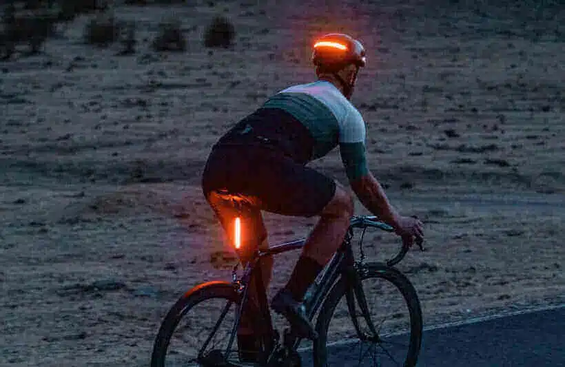 Fahrradfahrer mit Helm und Rücklicht, die im Dunkeln leuchten