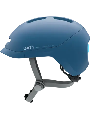 Ein blauer Sparky Junior Kinder-Smart-Helm, liegend auf grünem Hintergrund.