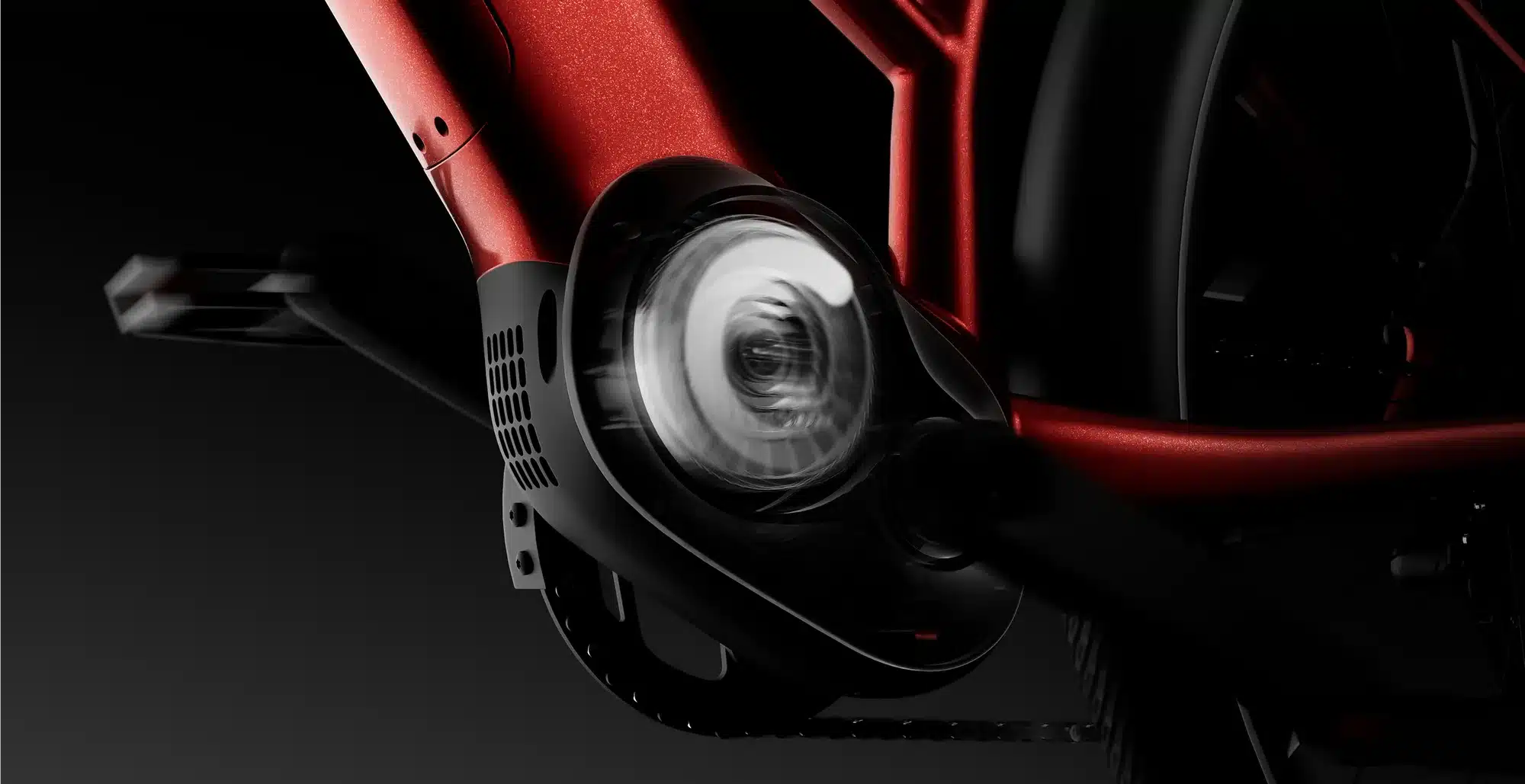 Nahaufnahme des roten Rahmens eines TENWAYS Ago Air E-Bikes, Fokus auf den schwarzen Mittelmotor und die Kette.