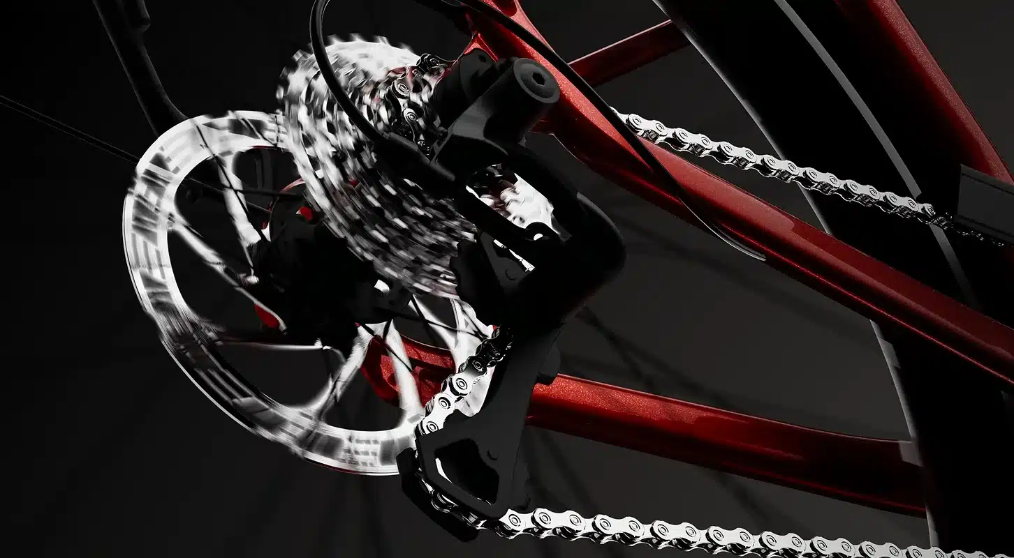 Nahaufnahme der hinteren Schaltkomponenten, der Kassette, der Kette und der Bremsscheibe eines TENWAYS Ago Air E-Bikes in glänzendem Rot.