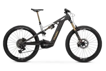 Seitenansicht eines schwarzen und grauen Thok TP4-Ltd E-Mountainbikes mit goldenen Akzenten an Gabel und Dämpfer.