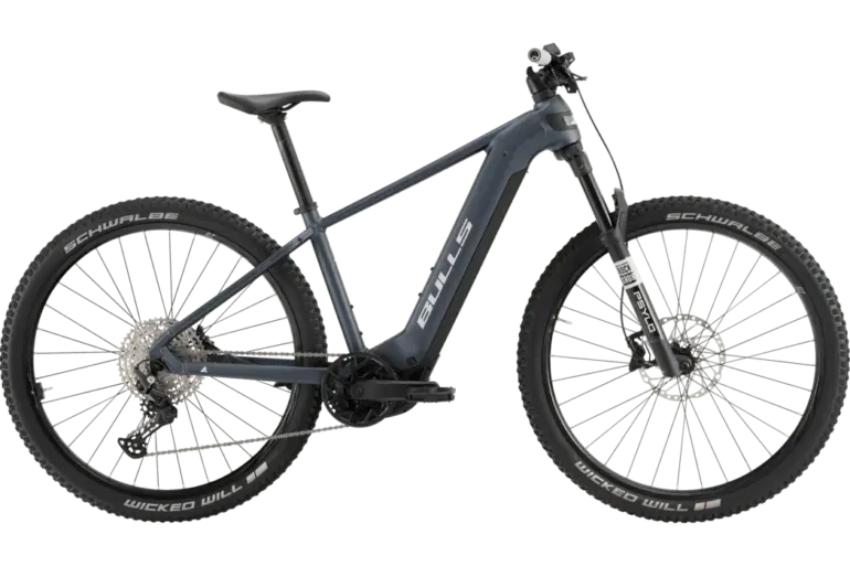 Seitenansicht eines grauen BULLS Copperhead EVO 2 2026 E-Mountainbikes auf grünem Hintergrund.