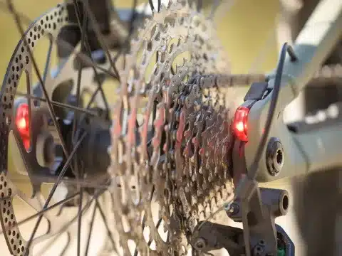 Nahaufnahme der Hinterradnabe eines E-Mountainbikes mit großem Ritzelpaket und integrierten roten Rückleuchten.