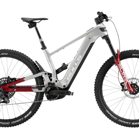 Seitenansicht des silbernen BULLS Copperhead EVO AM 4 2026 E-Mountainbikes mit roten Akzenten an der Federgabel und am Hinterbau.